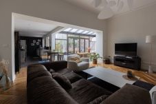„Geräumiges Wohnzimmer mit abgelagertem Parkettboden, bequemem Sofa und TV-Bereich, getaucht in eine luxuriöse Atmosphäre.“