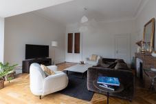„Neue Perspektive des Wohnzimmers mit abgelagertem Holzboden, bequemem Sofa und dekorativem Kamin im Hintergrund.“